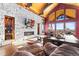 Cozy living room with a stone fireplace, wooden accents, and large windows offering serene views at 8456 N Sundown Trl, Parker, CO 80134