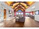 Spacious living room featuring stone fireplace, wood floors, vaulted ceilings, and stunning outdoor views at 8456 N Sundown Trl, Parker, CO 80134