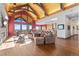Elegant living room with vaulted wood ceilings, stone fireplace, and an abundance of natural light at 8456 N Sundown Trl, Parker, CO 80134