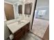 Bright bathroom with single sink vanity, light flooring, and entry to carpeted bedroom at 13992 E Marina Dr # 303, Aurora, CO 80014