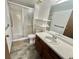 Bright bathroom features a glass shower, single sink vanity, neutral tones, and a wood-colored door at 13992 E Marina Dr # 303, Aurora, CO 80014