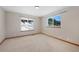 Empty bedroom featuring large windows and tan carpet at 87 Elmgreen Ln, Evergreen, CO 80439