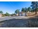 Exterior view of a detached garage, featuring a spacious driveway and mature trees at 87 Elmgreen Ln, Evergreen, CO 80439