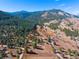 Aerial view of property lines, showing wooded acreage, valley view, and mountain backdrop at 87 Elmgreen Ln, Evergreen, CO 80439