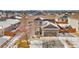Aerial view of a two-story home in a neighborhood with a two-car garage and snowy yard at 9121 Harlequin Cir, Frederick, CO 80504
