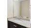 Bathroom featuring a granite countertop, dark cabinetry, and a large mirror at 9121 Harlequin Cir, Frederick, CO 80504