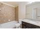Bathroom showcasing a granite countertop, wood cabinets, and a shower and bathtub with stone tiles at 9121 Harlequin Cir, Frederick, CO 80504