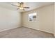 Comfortable carpeted bedroom includes a ceiling fan and a view of the neighborhood through the window at 9121 Harlequin Cir, Frederick, CO 80504