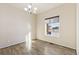 Dining room with hardwood flooring, a modern chandelier, and a sunlit window view at 9121 Harlequin Cir, Frederick, CO 80504