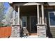 Inviting front entrance with stone pillars and dark trim creating a warm and welcoming ambiance at 9121 Harlequin Cir, Frederick, CO 80504