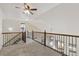 Loft area features a decorative wrought iron railing overlooking the lower level and a ceiling fan at 9121 Harlequin Cir, Frederick, CO 80504