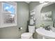 Charming powder room features a pedestal sink, a decorative mirror, and ample natural light at 510 W Prestwick Way, Castle Rock, CO 80104