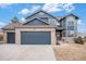 Charming two-story home with brick and blue siding, attached two-car garage and manicured front yard in daylight at 510 W Prestwick Way, Castle Rock, CO 80104