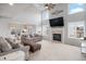 Spacious living room with a vaulted ceiling, fireplace, large television, and open access to the dining area at 510 W Prestwick Way, Castle Rock, CO 80104