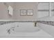 Relaxing soaking tub with white tile surround and decorative tile accent at 5179 S Fairplay St, Aurora, CO 80015