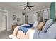 Bright bedroom with ceiling fan, bench, and sliding barn doors to bathroom at 5179 S Fairplay St, Aurora, CO 80015