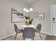 Dining area features a round table with modern chairs, artwork, and ample natural light at 5179 S Fairplay St, Aurora, CO 80015