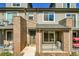 Inviting townhouse boasts brick accents, metal railings, and a covered front porch at 5179 S Fairplay St, Aurora, CO 80015