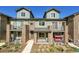Townhome with dual levels, private balconies, brick accents, and manicured front yard landscaping at 5179 S Fairplay St, Aurora, CO 80015