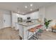 Modern kitchen features white cabinets, stainless steel appliances, and a large island with counter seating at 5179 S Fairplay St, Aurora, CO 80015