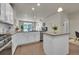 Bright, open-concept kitchen with stainless steel appliances, white cabinetry, and hardwood flooring at 5179 S Fairplay St, Aurora, CO 80015
