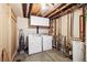 Unfinished utility basement with a washer and dryer, and exposed pipes, providing essential home functions at 8460 Corona St, Denver, CO 80229