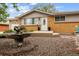 Attractive ranch-style home featuring brick and siding exterior, manicured landscaping, and front yard water feature at 8460 Corona St, Denver, CO 80229