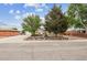 Inviting ranch-style home with mature trees, landscaping, rock accents, and charming front yard seating area at 8460 Corona St, Denver, CO 80229