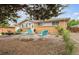 Delightful ranch-style home showcasing a well-kept front yard with rock landscaping and a cozy seating area at 8460 Corona St, Denver, CO 80229