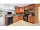 Stylish kitchen with stone countertops, black appliances, warm wood cabinets and breakfast bar seating at 8460 Corona St, Denver, CO 80229