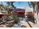 Charming backyard featuring a red awning, brick exterior, and lush greenery offering a private and inviting outdoor space at 3055 Clermont St, Denver, CO 80207
