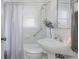 Clean white bathroom featuring a pedestal sink, tiled shower, and bright window, providing a refreshing and functional space at 3055 Clermont St, Denver, CO 80207