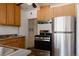 Well-lit kitchen with stainless steel appliances and wood cabinetry at 3055 Clermont St, Denver, CO 80207