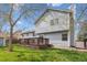 Rear exterior view of the home highlights a nice backyard with a wooden deck at 11908 W Aqueduct Dr, Littleton, CO 80127