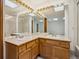 Bright bathroom features a double vanity, large mirror, and glass shower doors at 11908 W Aqueduct Dr, Littleton, CO 80127