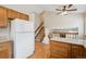 Bright kitchen with hardwood floors, white refrigerator and wooden cabinets at 11908 W Aqueduct Dr, Littleton, CO 80127