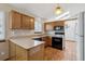 Charming kitchen featuring hardwood floors and plentiful counter space, under a skylight at 11908 W Aqueduct Dr, Littleton, CO 80127