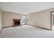 Spacious carpeted living room features a cozy brick fireplace and light-filled windows at 11908 W Aqueduct Dr, Littleton, CO 80127
