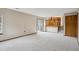 Open-concept living room with neutral carpeting, a sliding glass door, and wooden railing at 11908 W Aqueduct Dr, Littleton, CO 80127