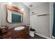 Bathroom featuring a decorative mirror, wood vanity, and white tile shower at 8901 Field St # 76, Broomfield, CO 80021