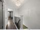 Hallway features modern chandelier, stair railing, and wood floors at 8901 Field St # 76, Broomfield, CO 80021