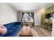 Bright living room featuring a large window with decorative curtains and wood floors at 8901 Field St # 76, Broomfield, CO 80021