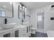 Bathroom featuring double sinks with modern vanity, light fixtures, mirrors and marble tile walls at 951 E 10Th Ave, Broomfield, CO 80020
