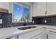 Beautiful kitchen with white cabinets, a modern faucet, and unique blue tile backsplash at 951 E 10Th Ave, Broomfield, CO 80020