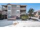 Three-story townhouse with snowy landscaping and trees at 12912 Ironstone Way # 101, Parker, CO 80134