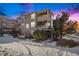 Evening view of a three-story townhouse with snow on the ground at 12912 Ironstone Way # 101, Parker, CO 80134