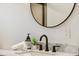 Elegant bathroom featuring a modern round mirror, marble countertop, and sleek black faucet at 4465 N Umatilla St, Denver, CO 80211
