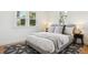 Cozy bedroom with two windows, neutral bedding, and stylish rug on hardwood floors at 4465 N Umatilla St, Denver, CO 80211