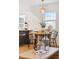Bright dining area featuring hardwood floors, a round wood table, and a stylish light fixture above at 4465 N Umatilla St, Denver, CO 80211