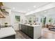 Open-concept kitchen featuring dark green cabinetry, a white island, and sleek appliances at 4465 N Umatilla St, Denver, CO 80211